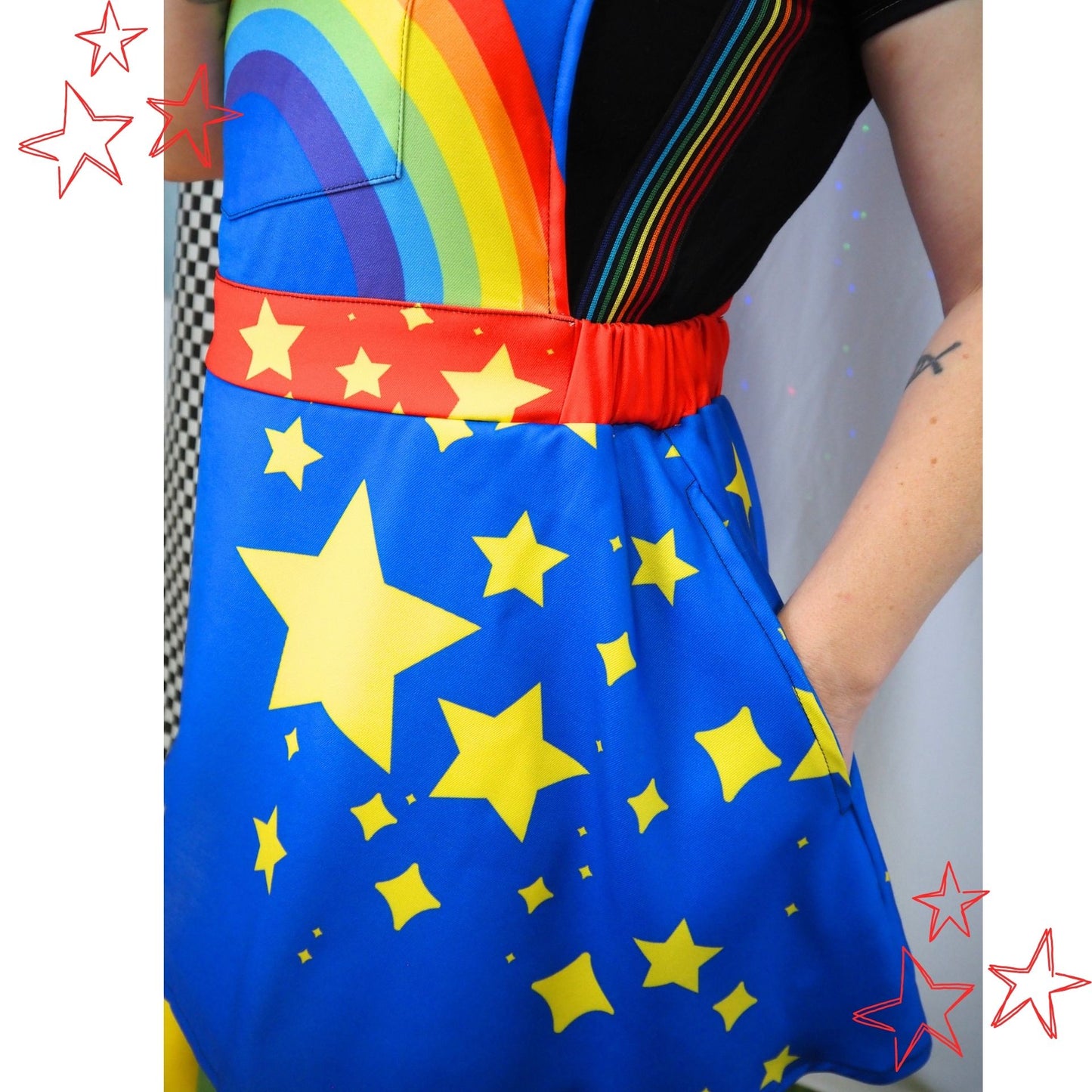 Colorful dress with rainbow top and star-patterned blue skirt on a plain background