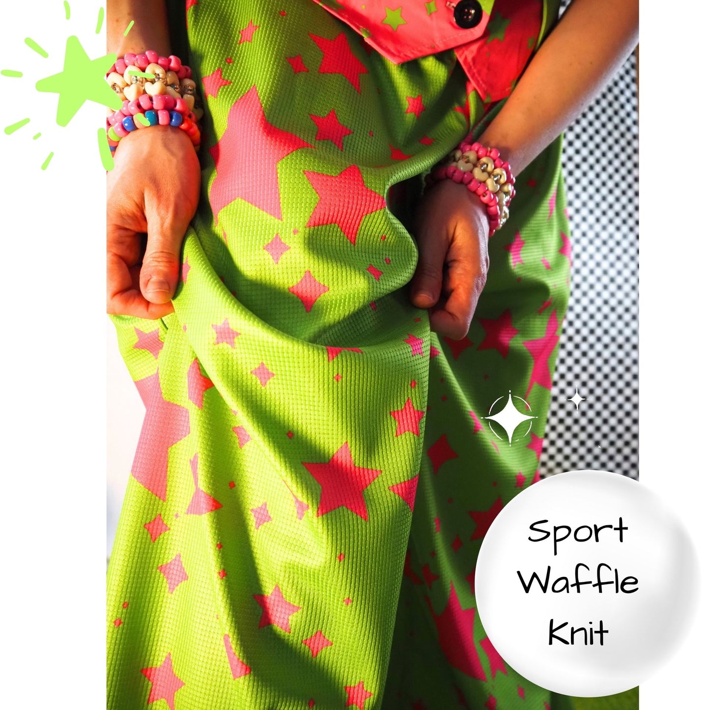 Green fabric with pink star patterns held by a person, labeled 'Sport Waffle Knit'.