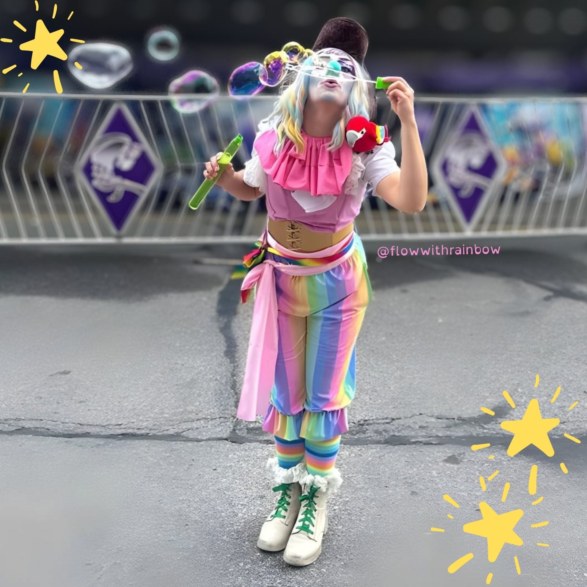 Person in colorful clown costume blowing bubbles on a street.
