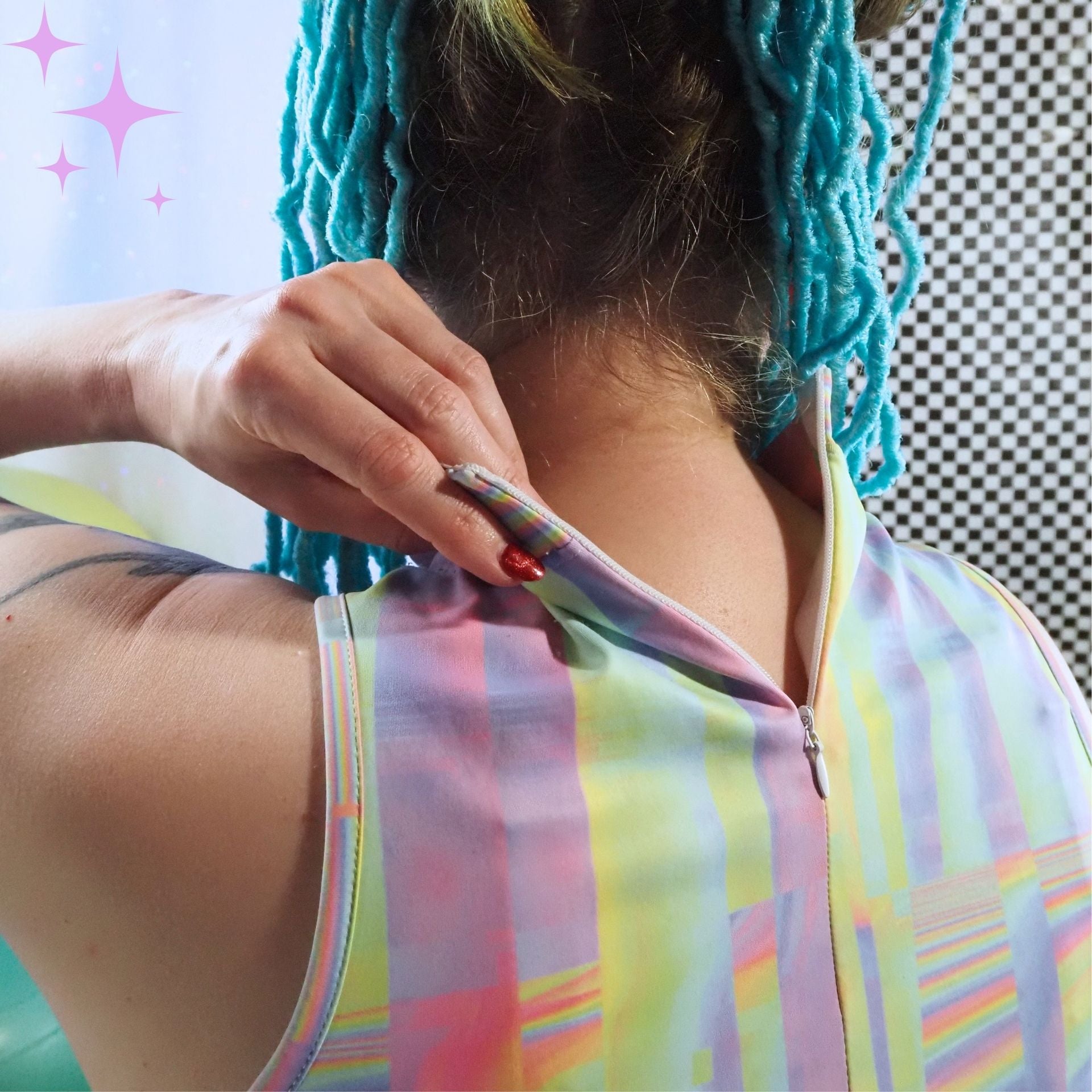Close-up of a person from the back wearing a pastel multicolor striped sleeveless top, with a hand adjusting the zipper at the neckline. The person has bright turquoise braided hair, and the background is a mix of a light blue wall and a black-and-white checkered pattern.