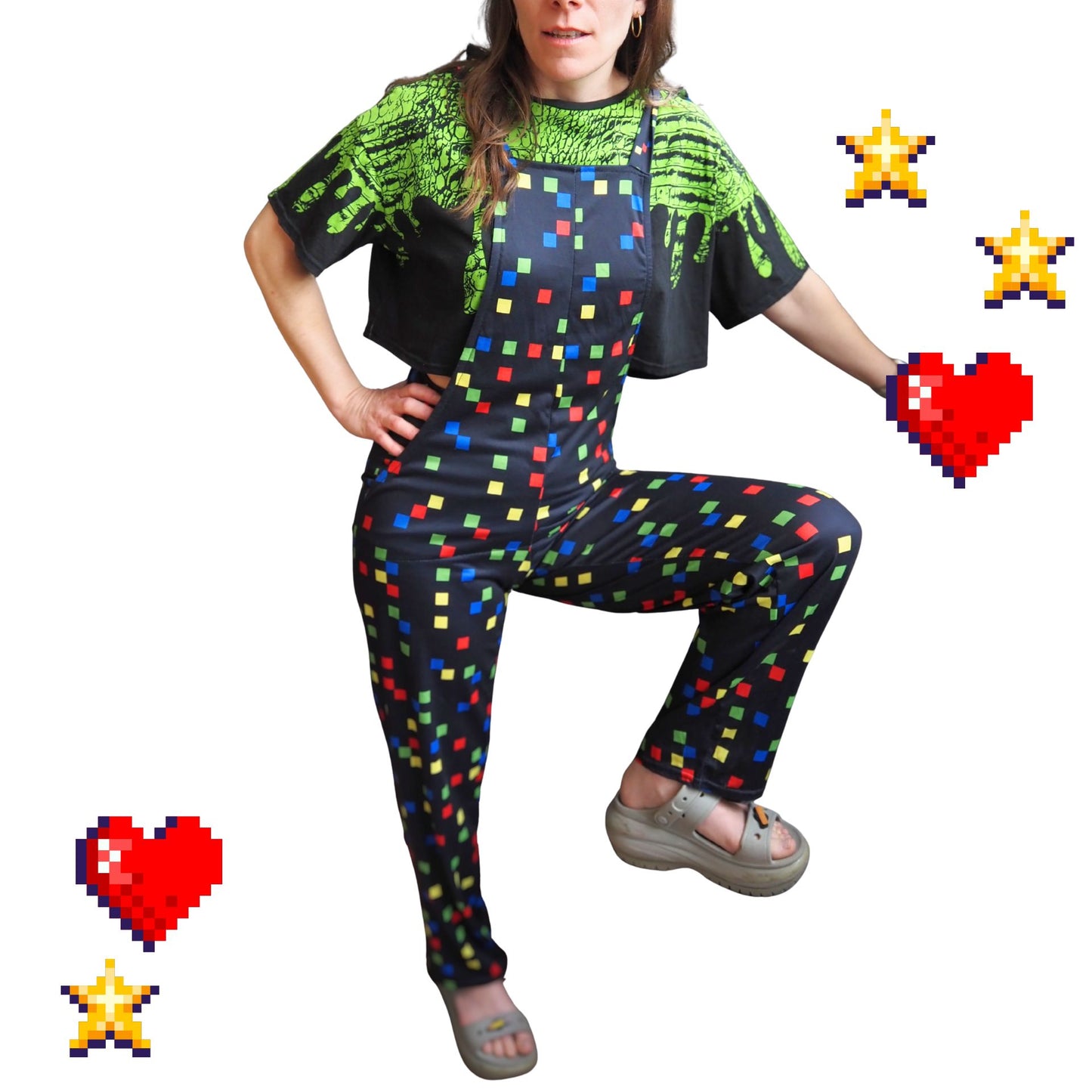 Person wearing a colorful outfit with cute black overalls with little colored squares on them in red, yellow, blue and green