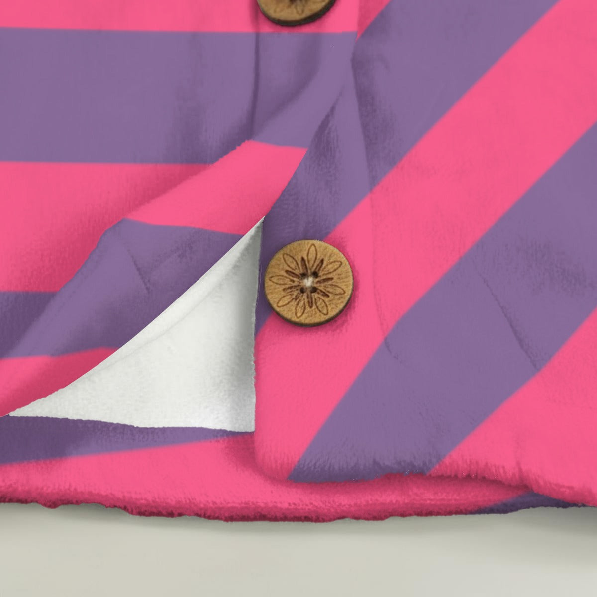Close-up of a pink and purple striped fabric with a coconut button
