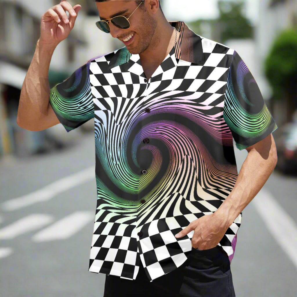 Man wearing a shirt with a checkered and spiral design on a street.