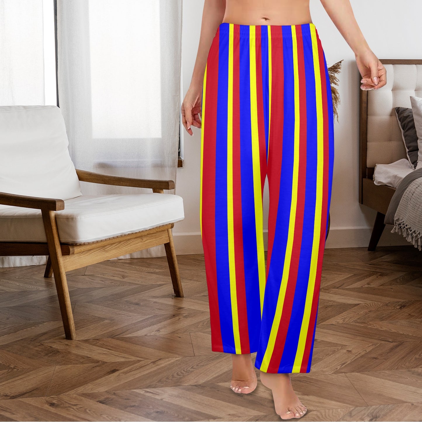 Person wearing colorful striped pants in a room with a chair and bed.