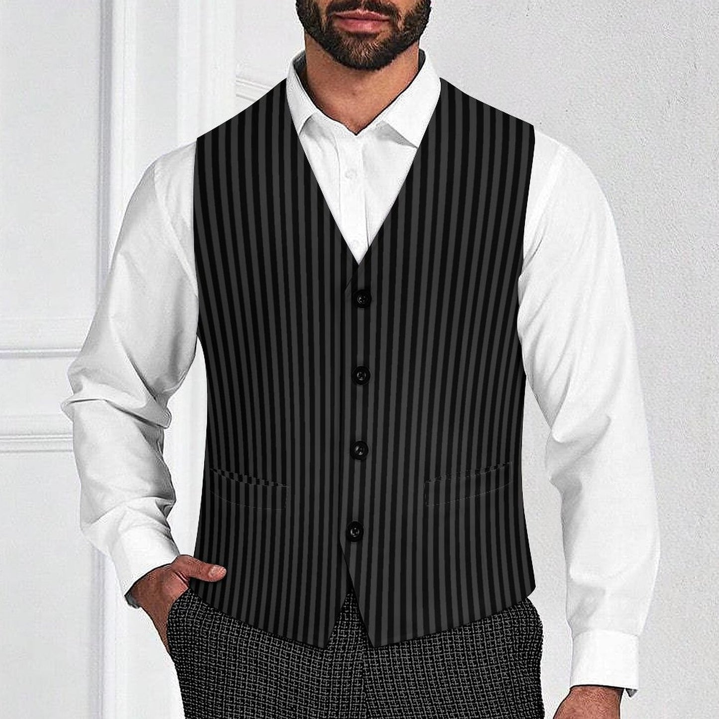 Man wearing a black pinstripe vest over a white shirt with a plain background