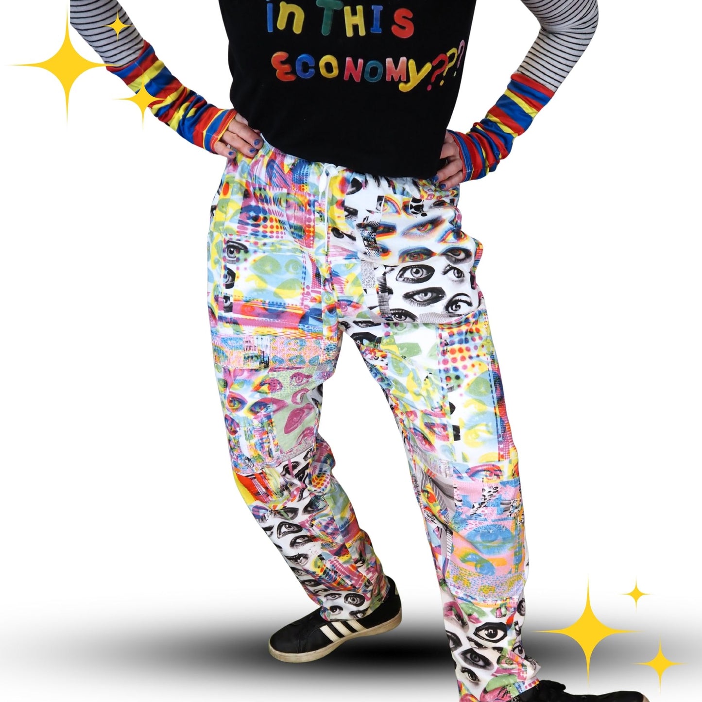 Person wearing colorful pants with a graphic design and rainbow sleeves on a white background.