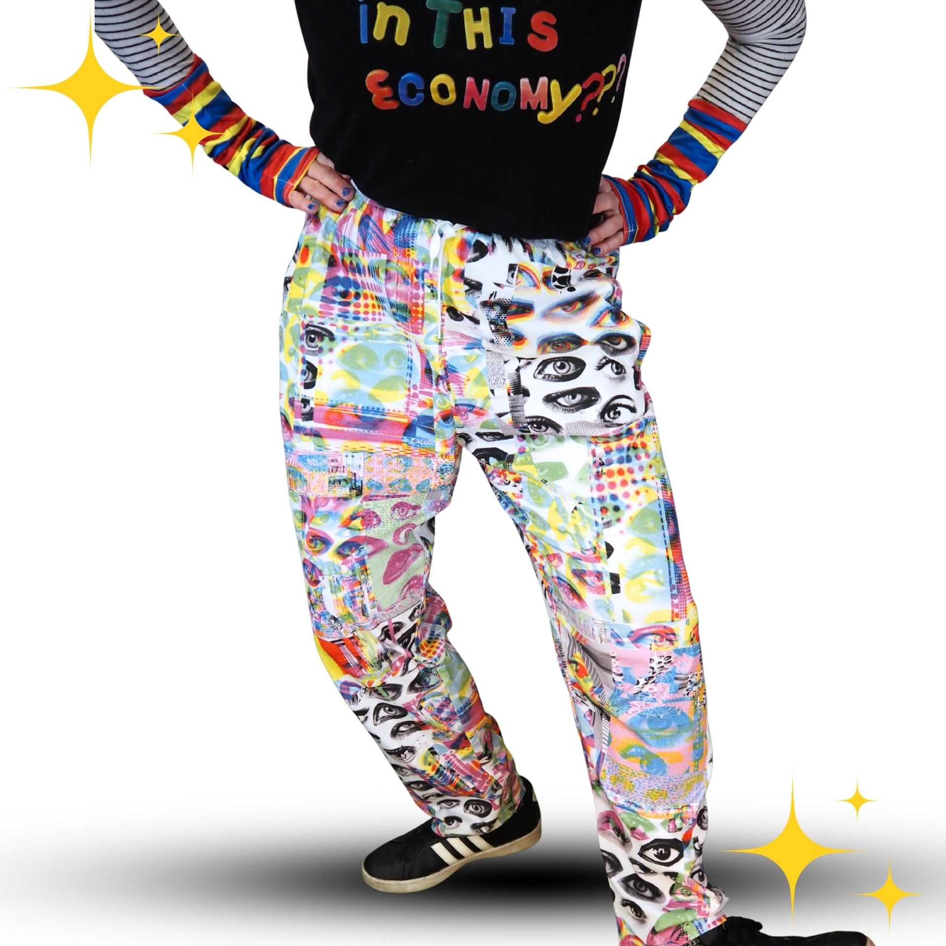 Person wearing colorful pants with a graphic design and rainbow sleeves on a white background.