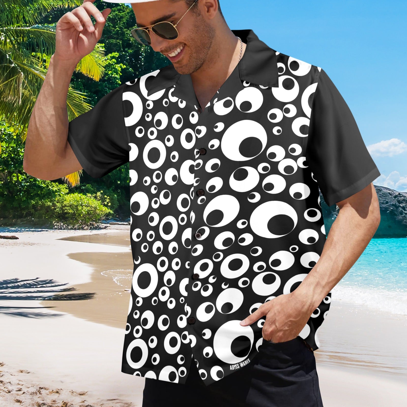 Man wearing a black and white patterned shirt on a beach
