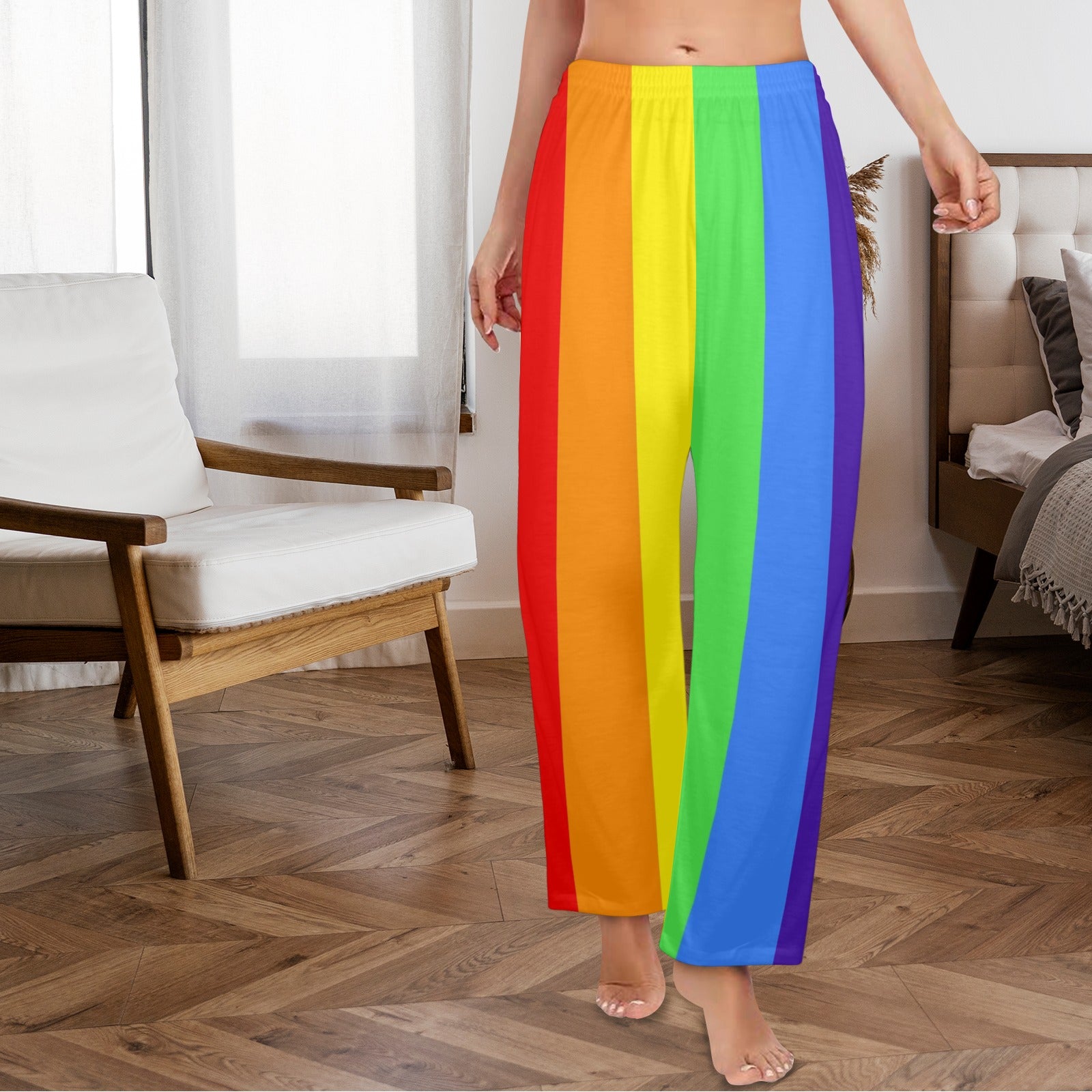Person wearing rainbow striped pants in a room with wooden floor and furniture.