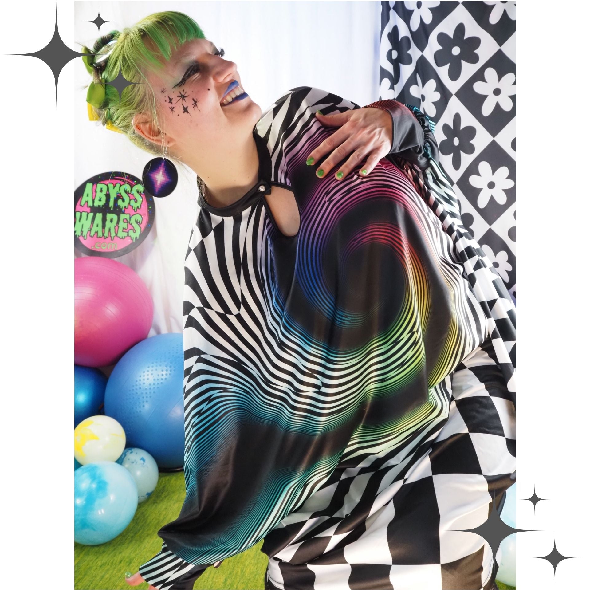 Person wearing a colorful, patterned garment with a checkered floor and balloons in the background