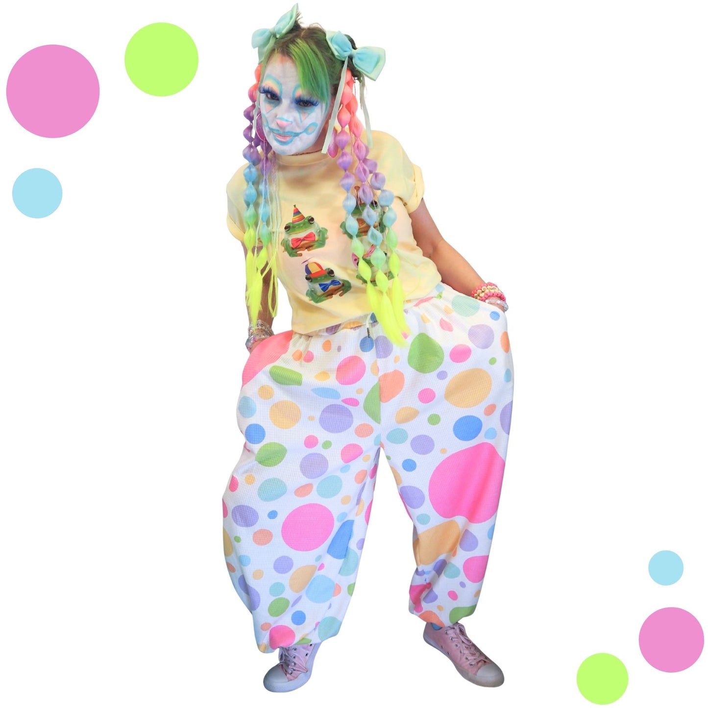 Person in colorful clown costume with polka dot pants and face paint on a white background