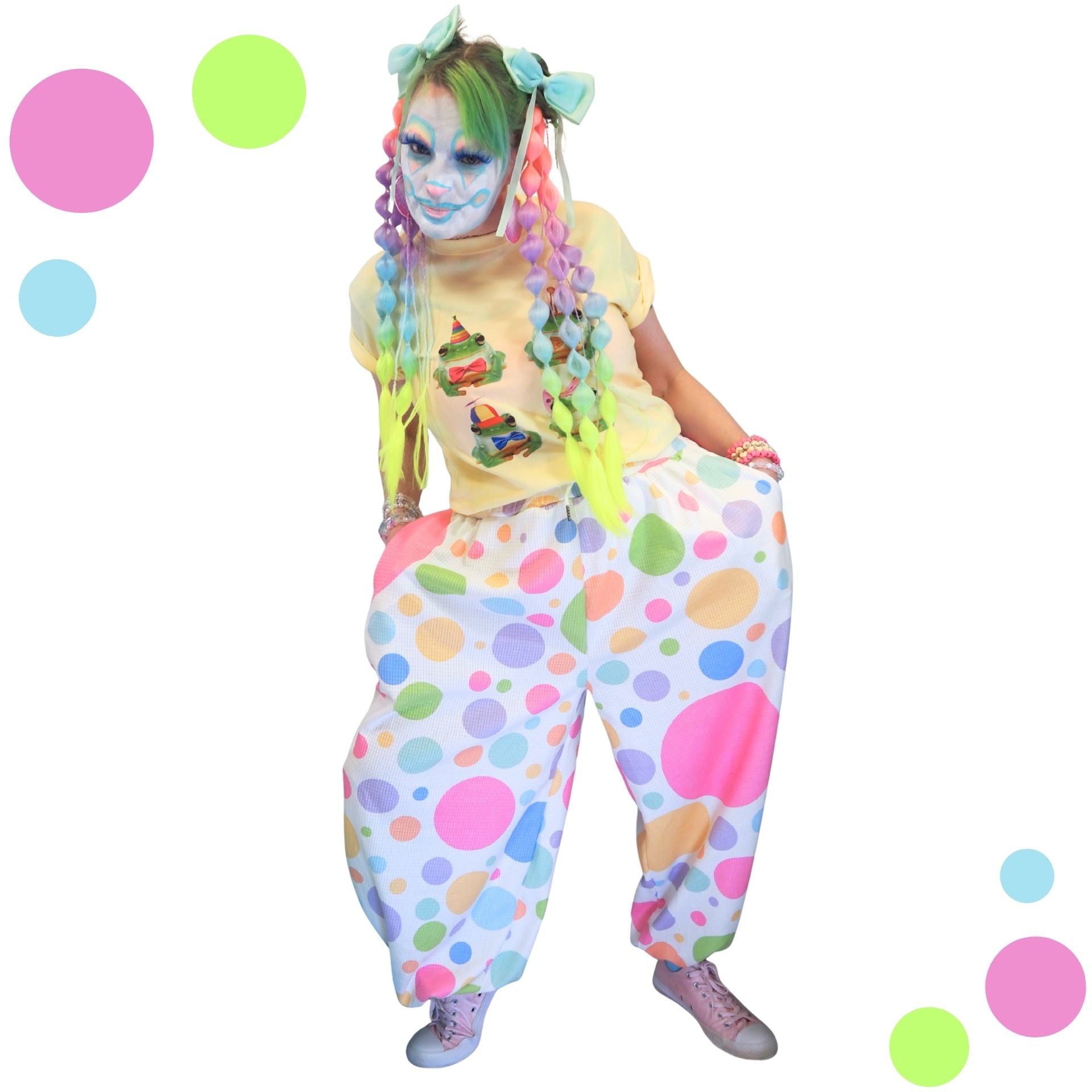 Person in colorful clown costume with polka dot pants and face paint on a white background