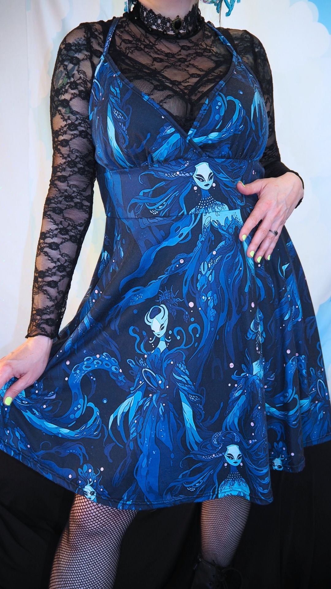 Blue dress with intricate design and sheer sleeves worn by a person.