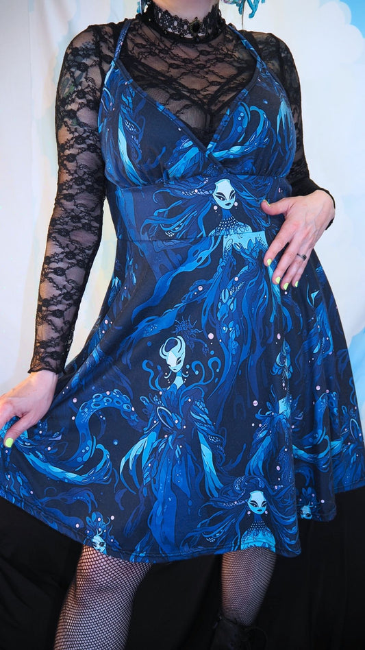 Blue dress with intricate design and sheer sleeves worn by a person.