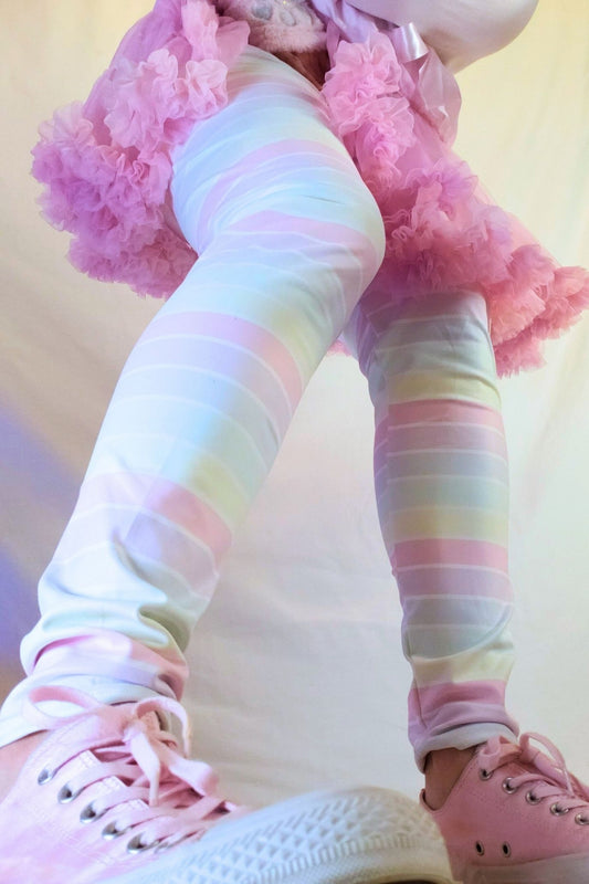 Pastel rainbow leggings with pink shoes on a light background