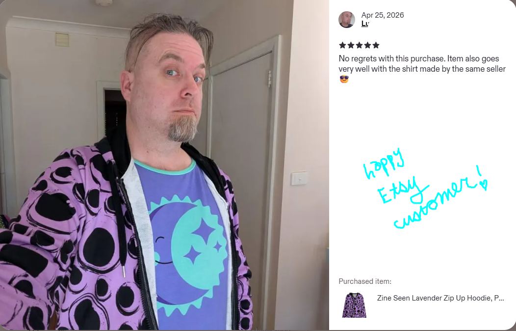 Person wearing a purple hoodie with black googly eye patterns, standing in a room.