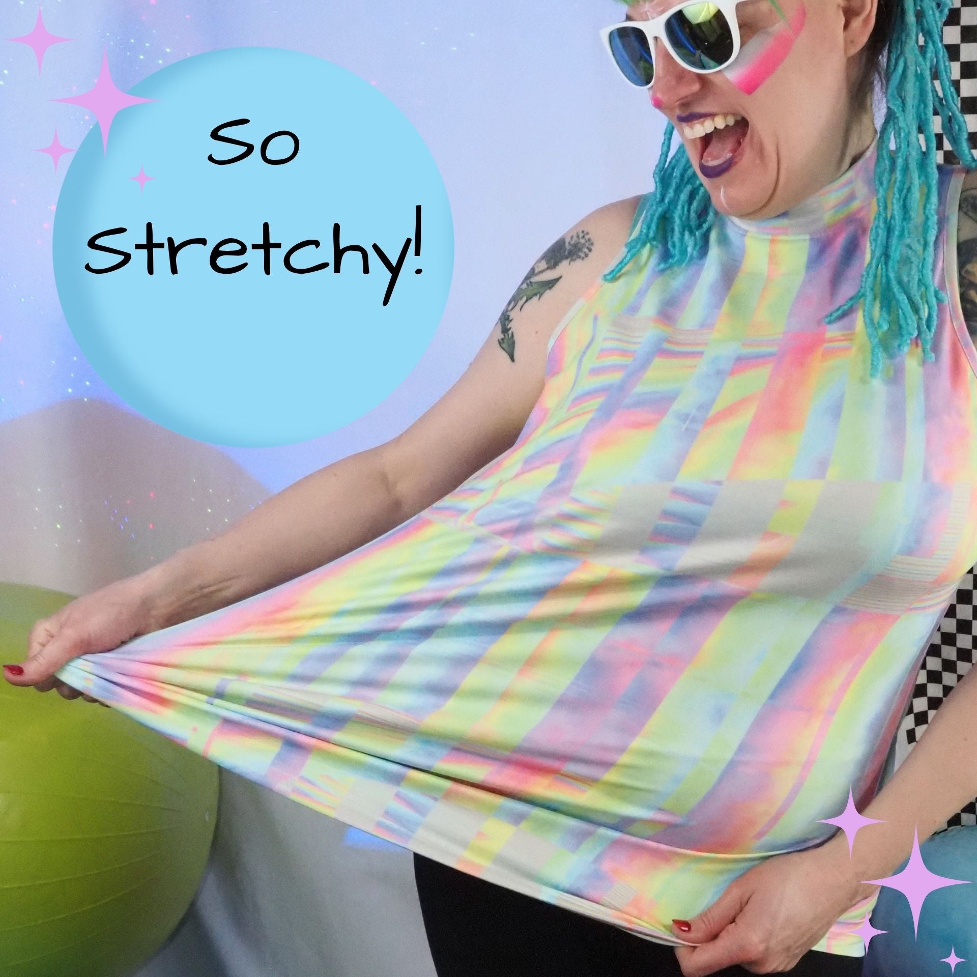 A woman wearing a pastel rainbow striped high-neck tank top stretches the fabric outward to demonstrate its elasticity. She is wearing white sunglasses with pink lenses and has blue braided hair.