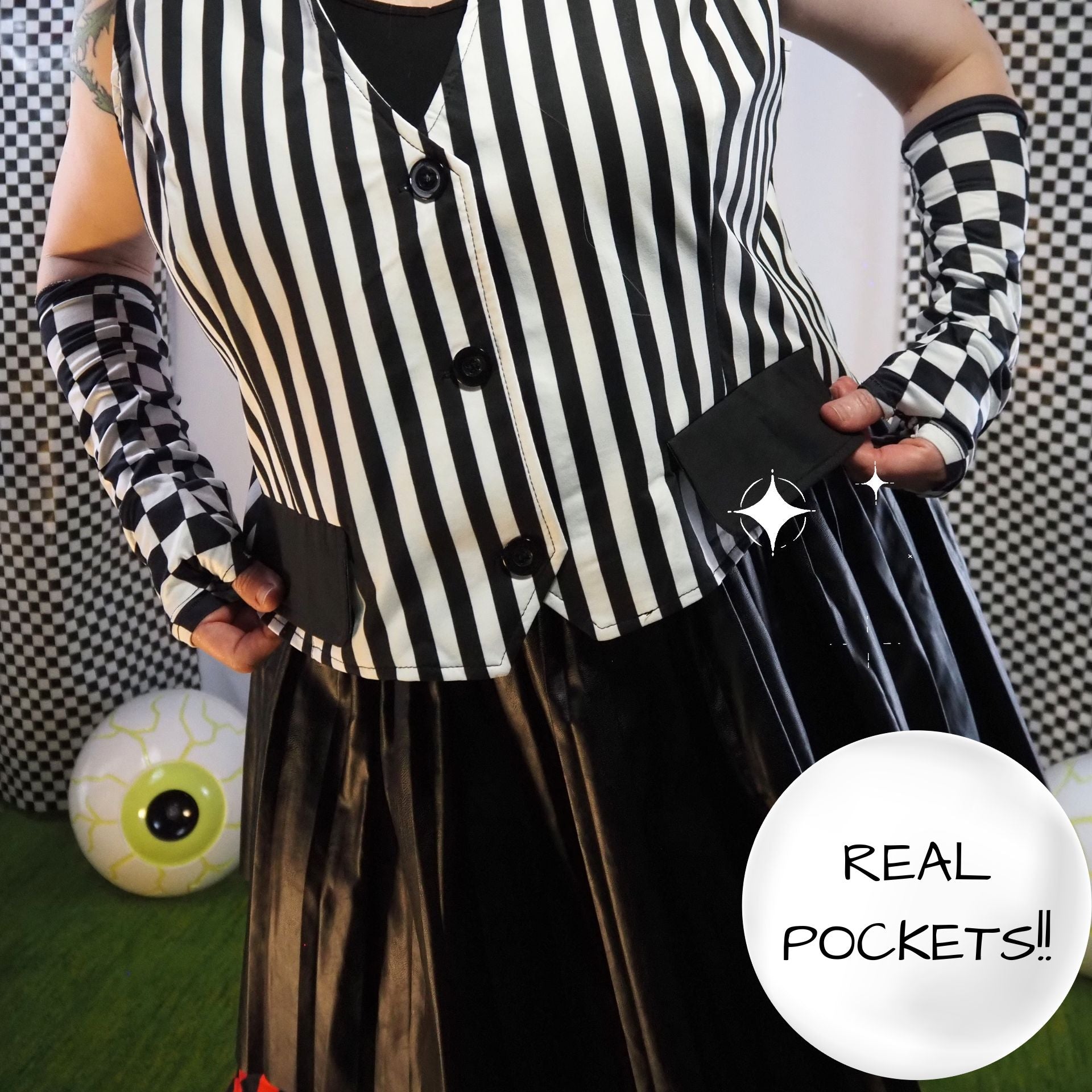 Person wearing a black and white striped shirt with checkered sleeves and gloves, holding a belt with a star buckle.