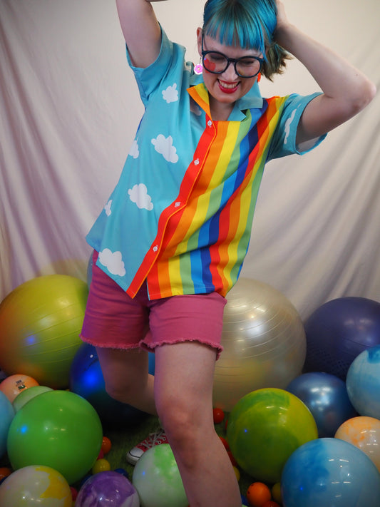 Person in a colorful dress surrounded by balloons on a light background