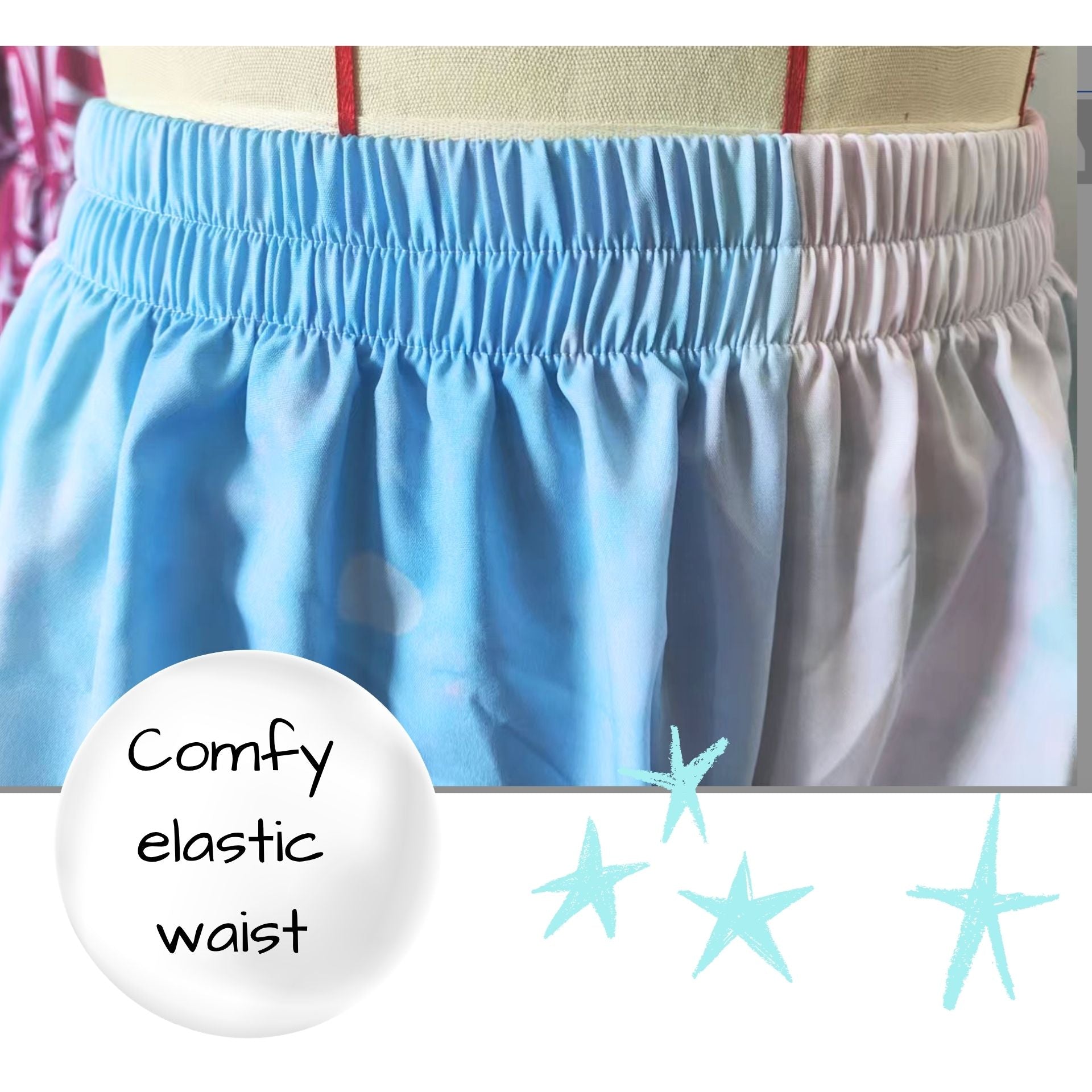 Close-up of blue shorts with a white label indicating 'Comfy elastic waist' on a blurred background.