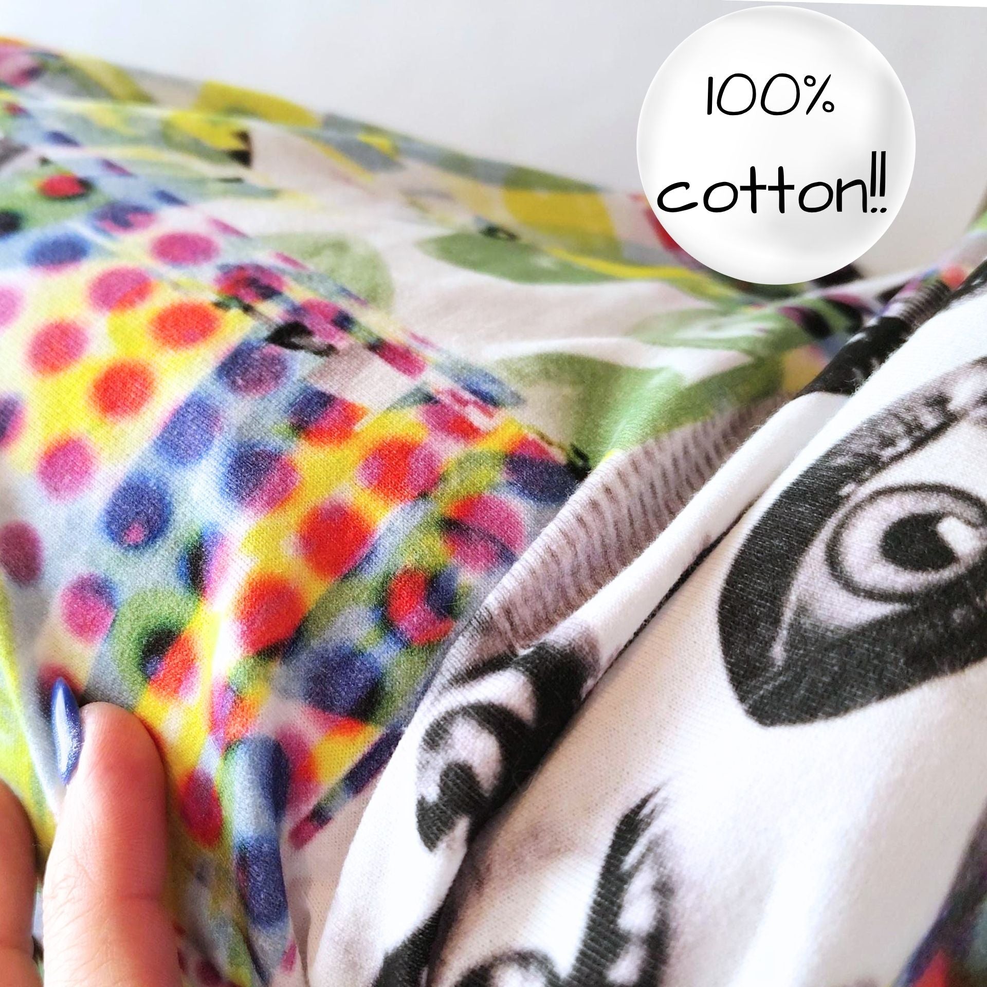 Colorful fabric with patterns and a hand holding it, featuring a label indicating 100% cotton.